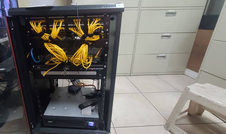 An equipment rack with yellow patch cables routed in a neat sweep between panels