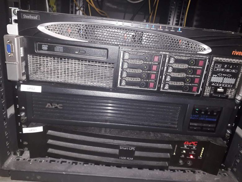 A rack-mounted server above an APC Smart-UPS in an equipment cabinet